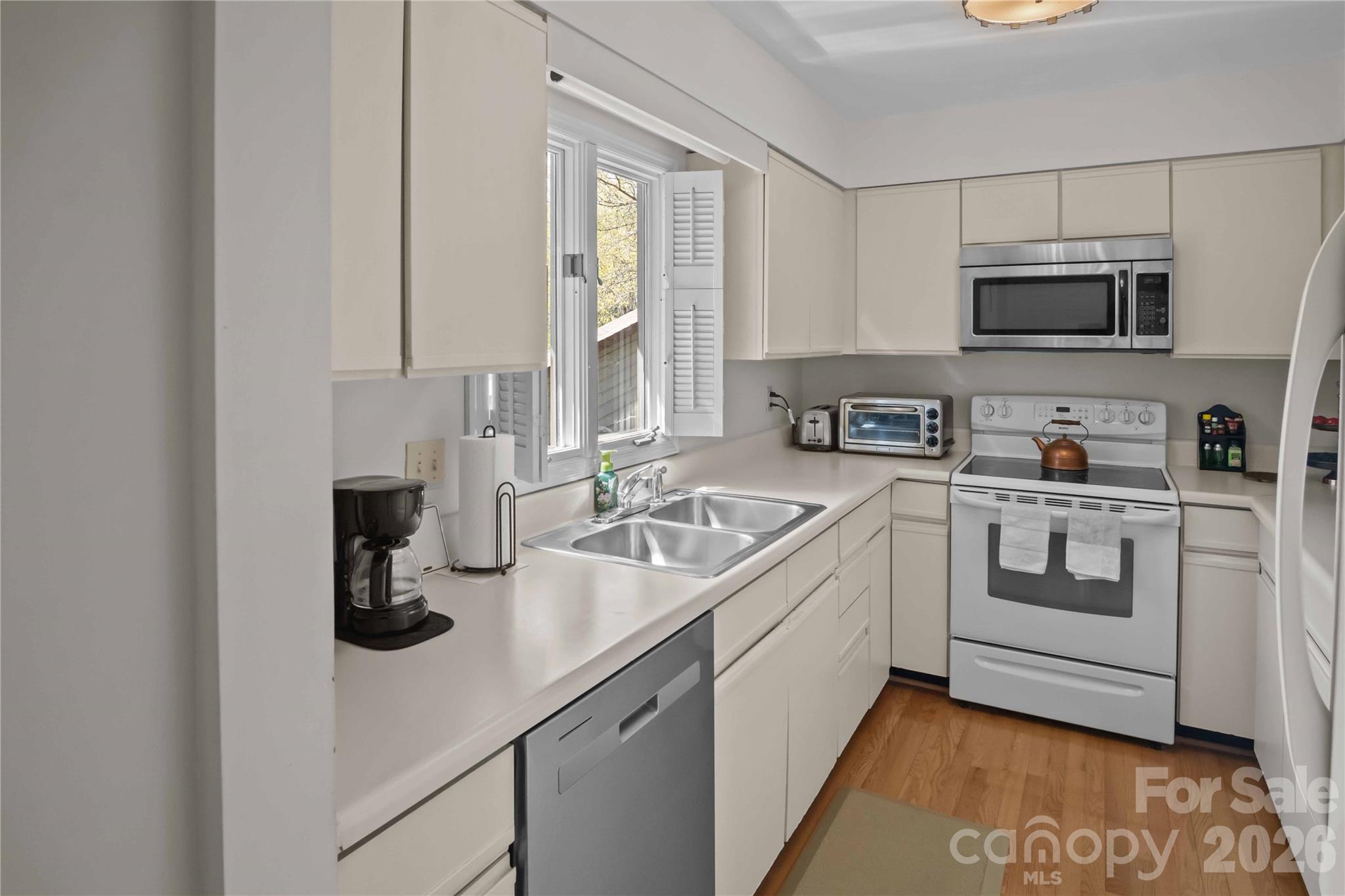 335 Melrose Avenue, Unit 103 Tryon, NC 28782 - Photo 27 of 38 a kitchen with stainless steel appliances granite countertop a sink a stove and a refrigerator