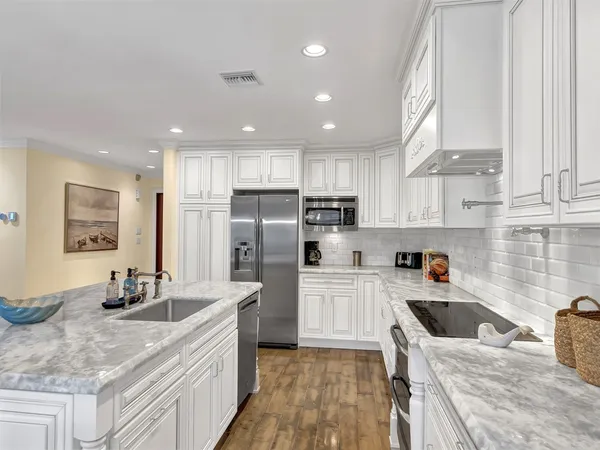 a kitchen with stainless steel appliances granite countertop a sink stove and refrigerator