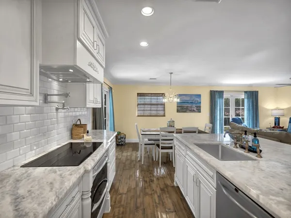 a kitchen with stainless steel appliances granite countertop a sink stove and cabinets