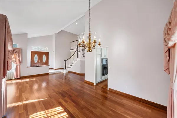 a view of a livingroom with wooden floor and a ceiling fan