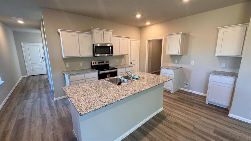 325 Wildrose Circle Cleburne, TX 76033 - Photo 22 of 24 a kitchen with stainless steel appliances granite countertop a sink stove and refrigerator