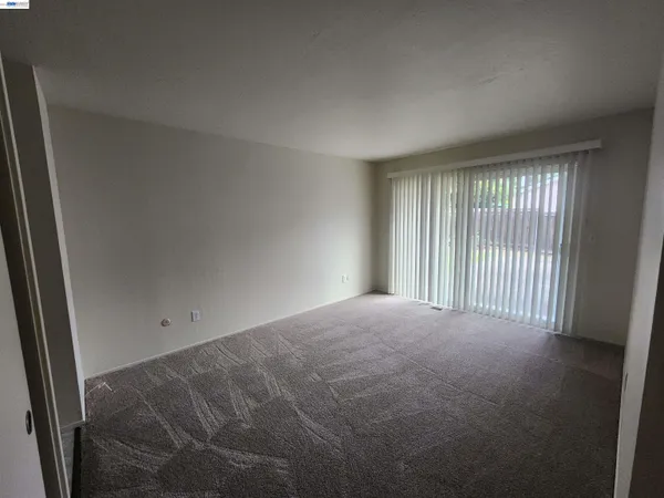 a view of a livingroom with an empty space and a window