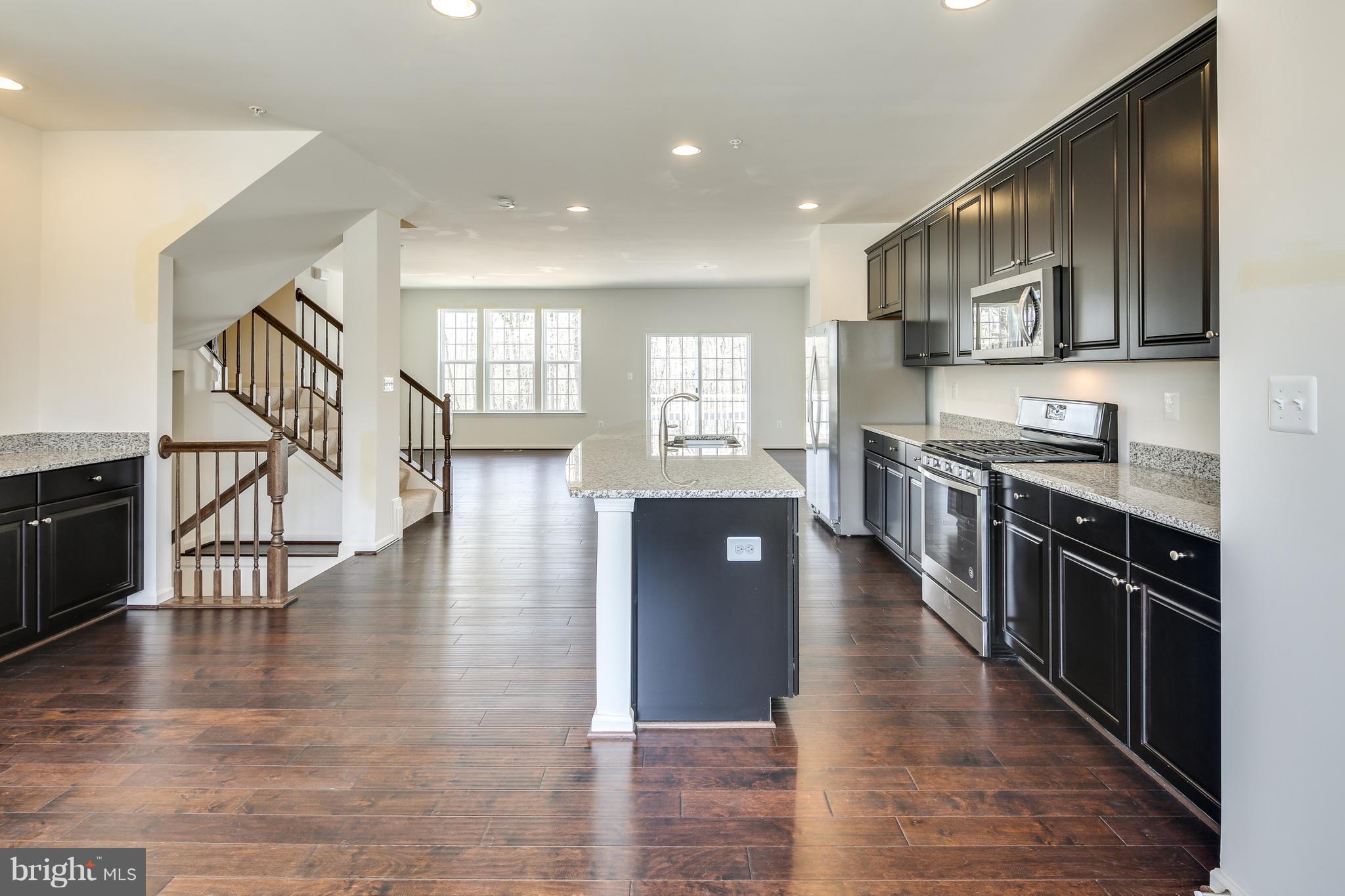 904 Morgan Run Road Baltimore, MD 21220 - Photo 5 of 23 a kitchen with stainless steel appliances granite countertop lots of counter top space and wooden floor