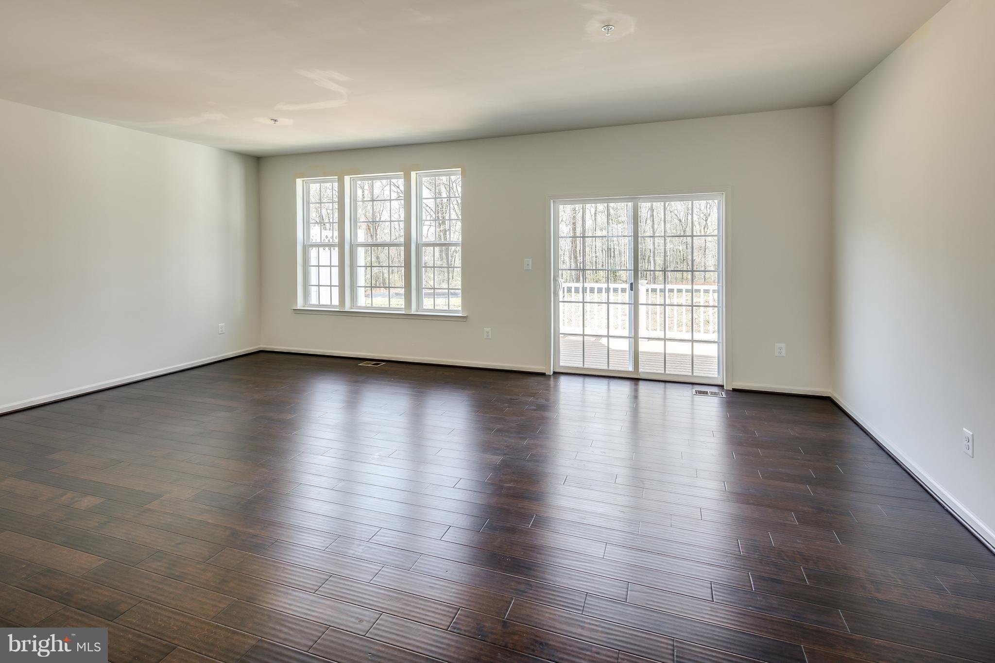 904 Morgan Run Road Baltimore, MD 21220 - Photo 9 of 23 a view of an empty room with wooden floor and a window