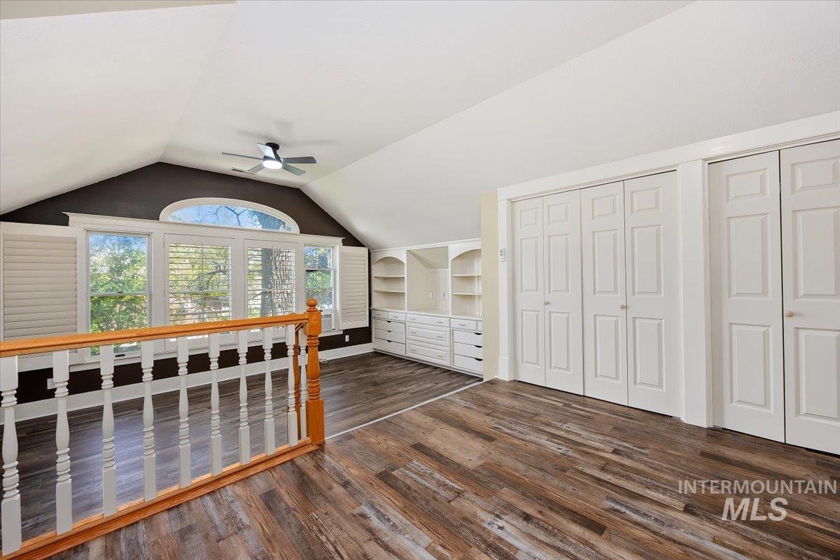 813 7th Street Rupert, ID 83350 - Photo 30 of 48 Vaulted ceiling room with wood-finish flooring, featuring a series of windows with plantation shutters, built-in cabinetry, and white bi-fold closet doors