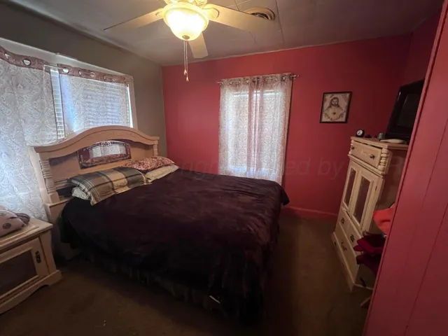 a bedroom with a bed next to a window