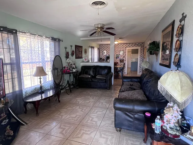 a living room with furniture a flat screen tv and a window