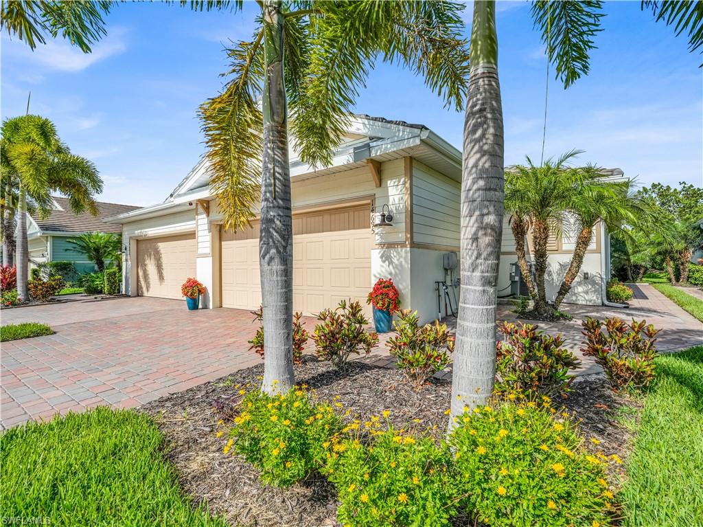 14695 Edgewater Circle Naples, FL 34114 - Photo 2 of 39 a front view of a house with garden