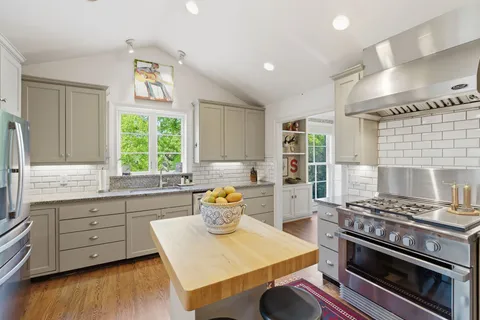 a kitchen that has a stove and a wooden cabinets