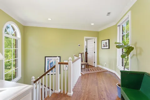 a view of a big room with windows wooden floor and front door