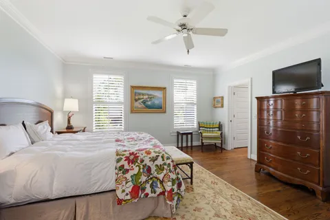 a bedroom with a bed a flat screen tv and dresser