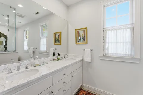 a bathroom with double sink and a mirror