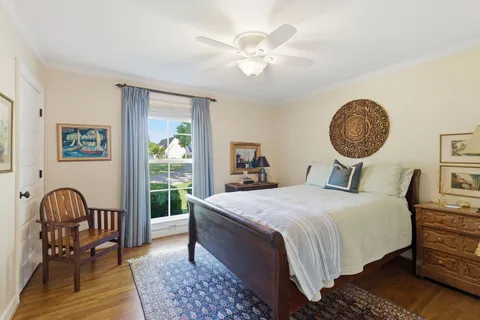 a bedroom with a bed a chandelier and a window