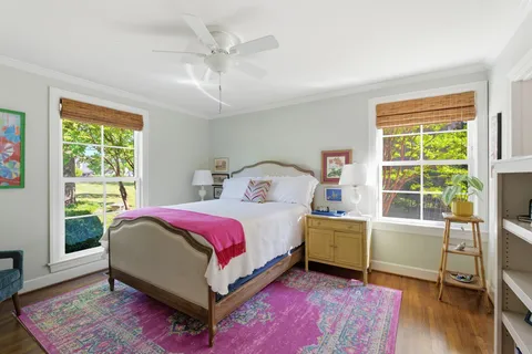 a bedroom with a bed and wooden floor