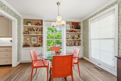 a dining room with furniture a window and wooden floor