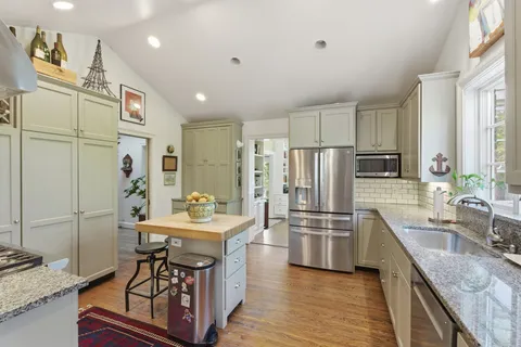a kitchen with stainless steel appliances granite countertop a sink stove and refrigerator