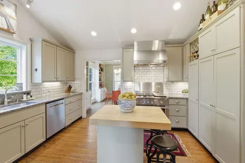 a kitchen with sink refrigerator and large window