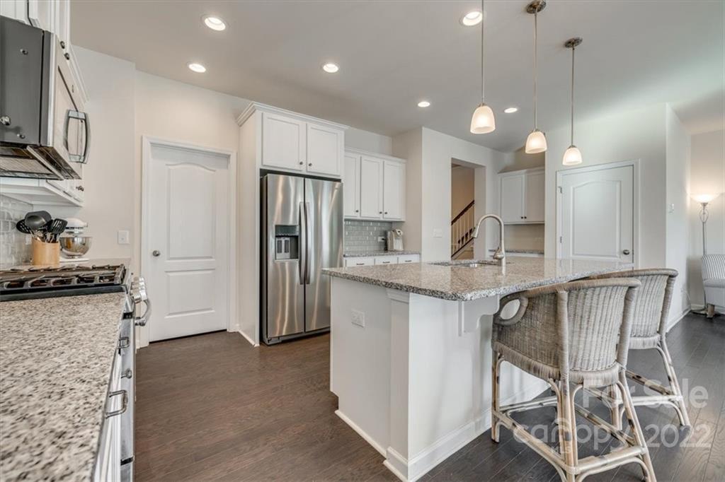 533 Dulaney Drive Fort Mill, SC 29708 - Photo 8 of 31 a kitchen with granite countertop a table chairs refrigerator and microwave