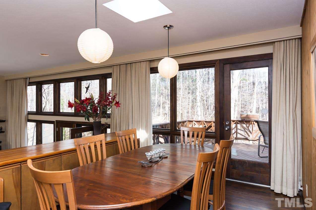 1500 Southview Road Durham, NC 27703 - Photo 9 of 22 a dining room with wooden floor a chandelier a glass table and chairs