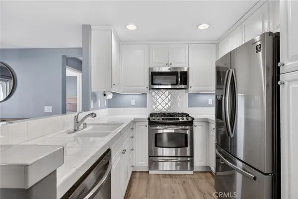 a kitchen with a sink stainless steel appliances and refrigerator