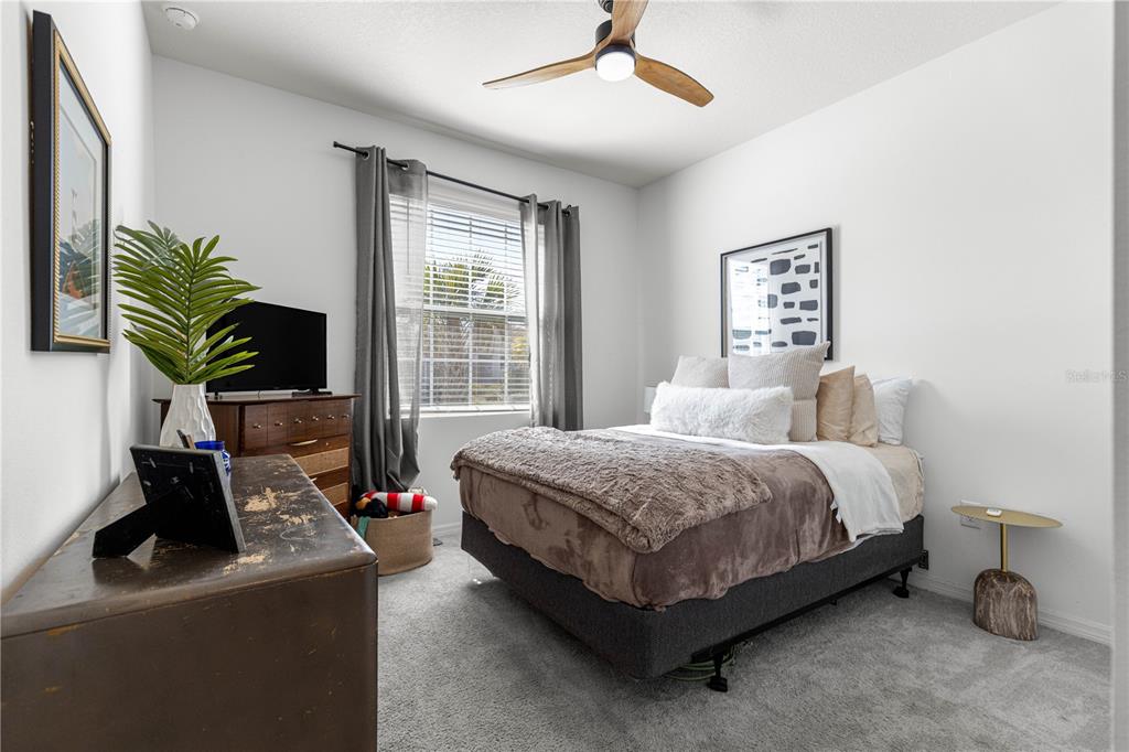 5377 Northwest 46th Lane Road Ocala, FL 34482 - Photo 32 of 59 a spacious bedroom with a bed a large window and flat screen tv