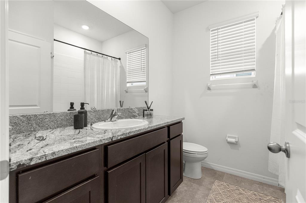 5377 Northwest 46th Lane Road Ocala, FL 34482 - Photo 36 of 59 a bathroom with a granite countertop sink toilet and mirror
