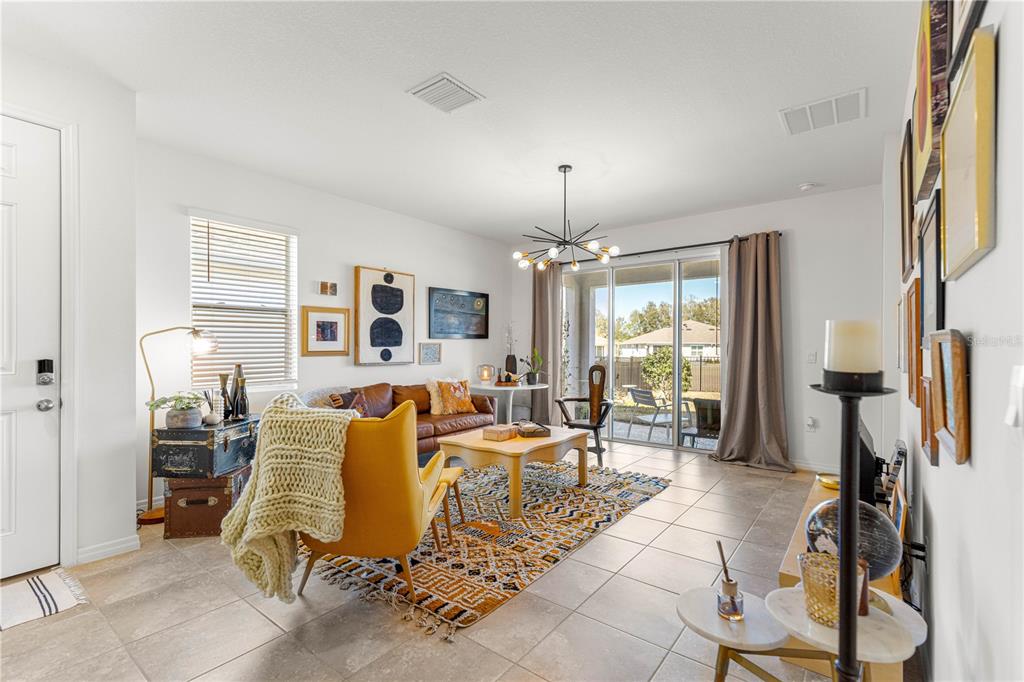 5377 Northwest 46th Lane Road Ocala, FL 34482 - Photo 6 of 59 a living room with furniture a chandelier and a flat screen tv