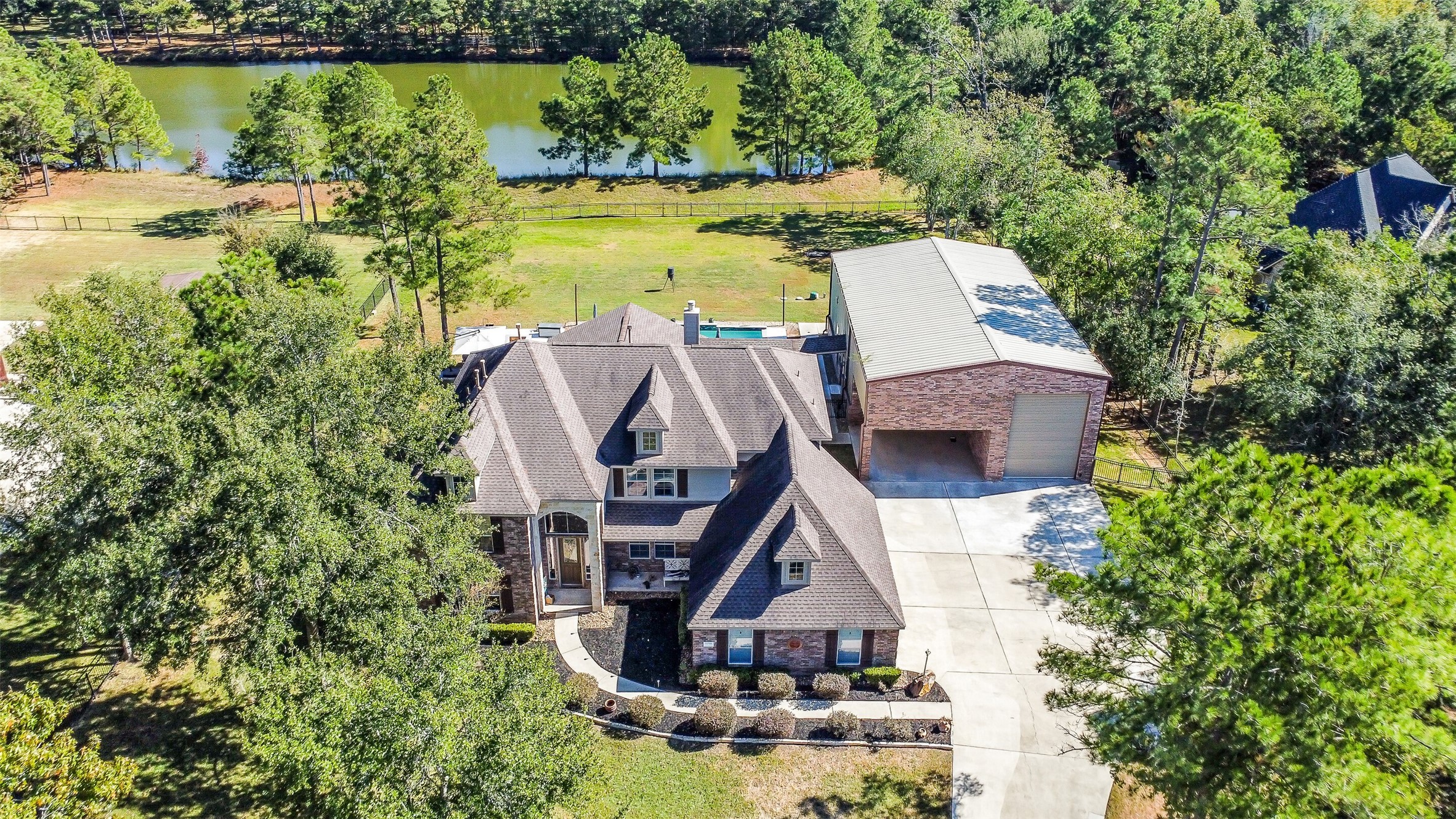 32711 Tall Oaks Way Magnolia, TX 77354 - Photo 2 of 50 an aerial view of a house with swimming pool and lake view