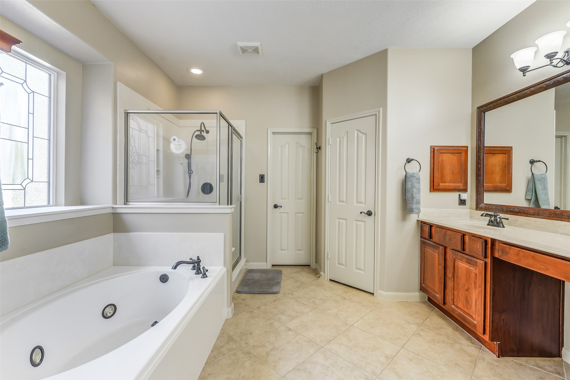 32711 Tall Oaks Way Magnolia, TX 77354 - Photo 23 of 50 a bathroom with a tub a sink and a large mirror