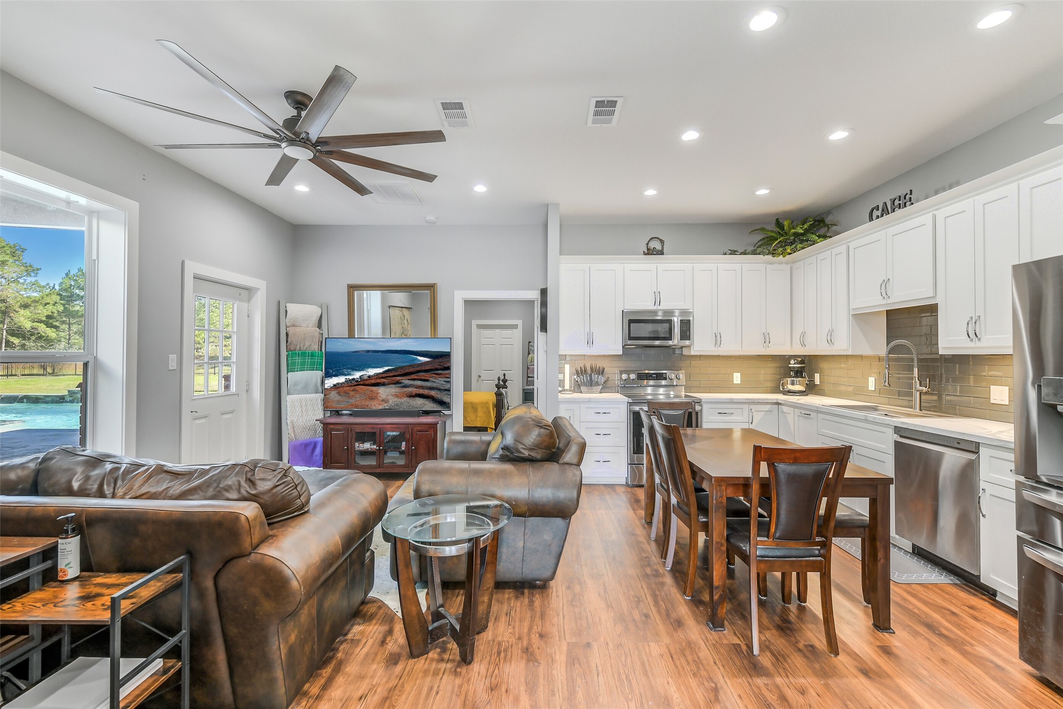 32711 Tall Oaks Way Magnolia, TX 77354 - Photo 41 of 50 a living room with stainless steel appliances kitchen island granite countertop furniture and a large window