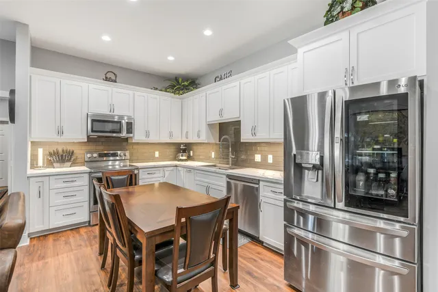 a kitchen with granite countertop a refrigerator stove top oven and sink