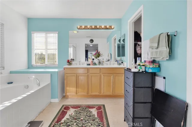 a spacious bathroom with a double vanity sink mirror and bathtub