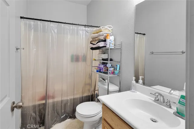 a bathroom with a sink a toilet and shower curtain