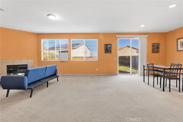 a living room with furniture a flat screen tv and floor to ceiling window