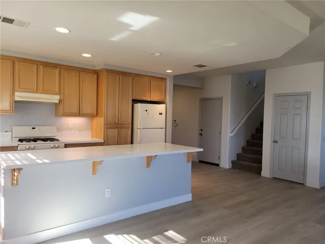 a kitchen with stainless steel appliances granite countertop a refrigerator a sink and a stove