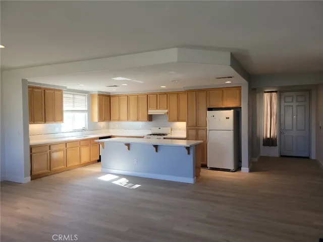 a kitchen with a refrigerator and a stove top oven