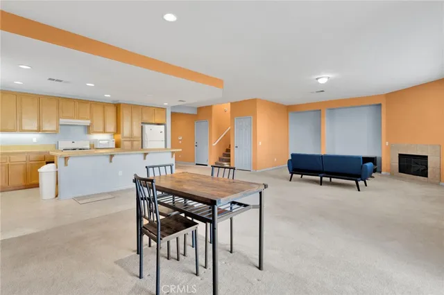 a living room with furniture a table and kitchen view