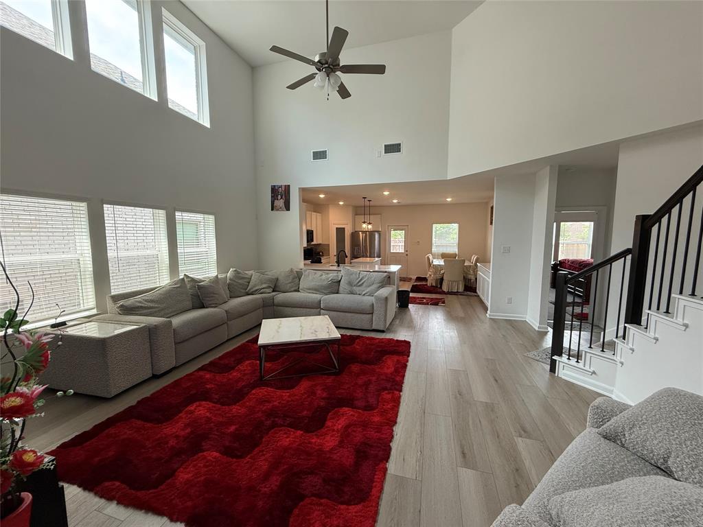 2006 Placerville Street Forney, TX 75126 - Photo 6 of 35 Soaring ceilings with upper windows, wood-finish flooring, and a contemporary ceiling fan