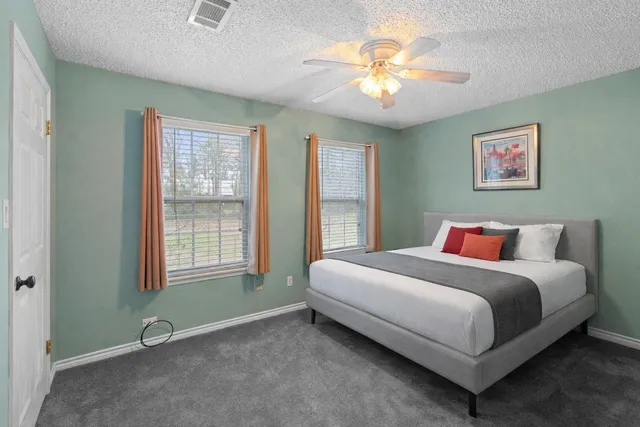 a spacious bedroom with a bed and a chandelier