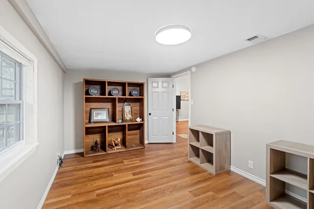 a view of a workspace with furniture and a window
