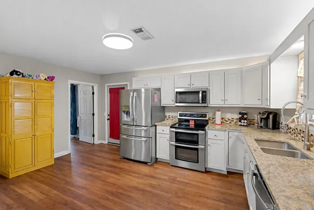 a kitchen with stainless steel appliances granite countertop a refrigerator and a stove top oven