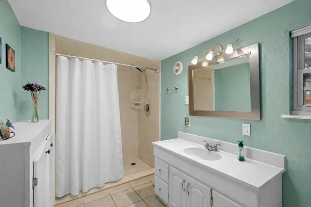 a bathroom with double vanity sink a mirror and a shower