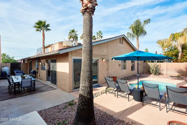 a view of a patio with a table and chairs under an umbrella