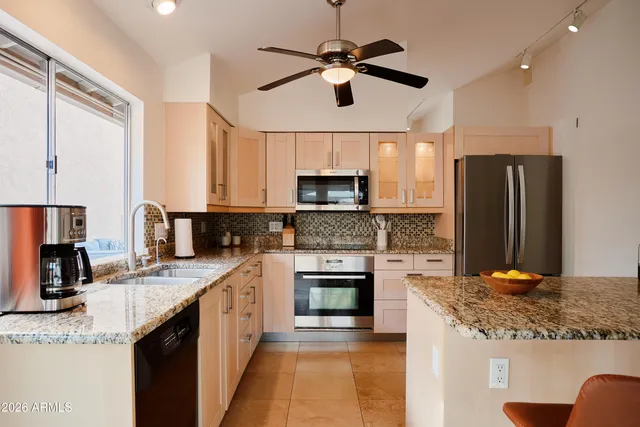 a kitchen with stainless steel appliances granite countertop a sink stove and refrigerator