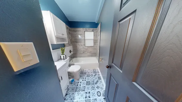 a bathroom with a granite countertop sink toilet and shower