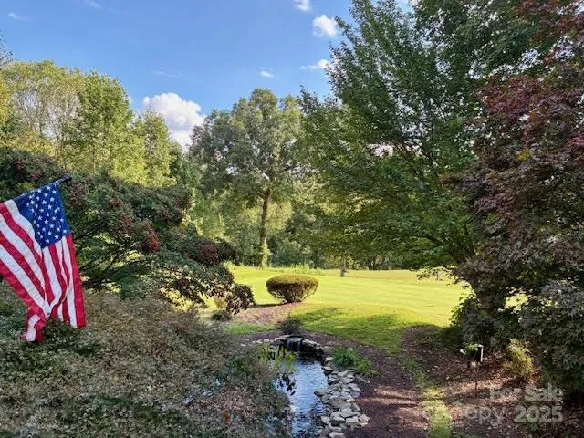 a view of house with outdoor seating and covered with trees
