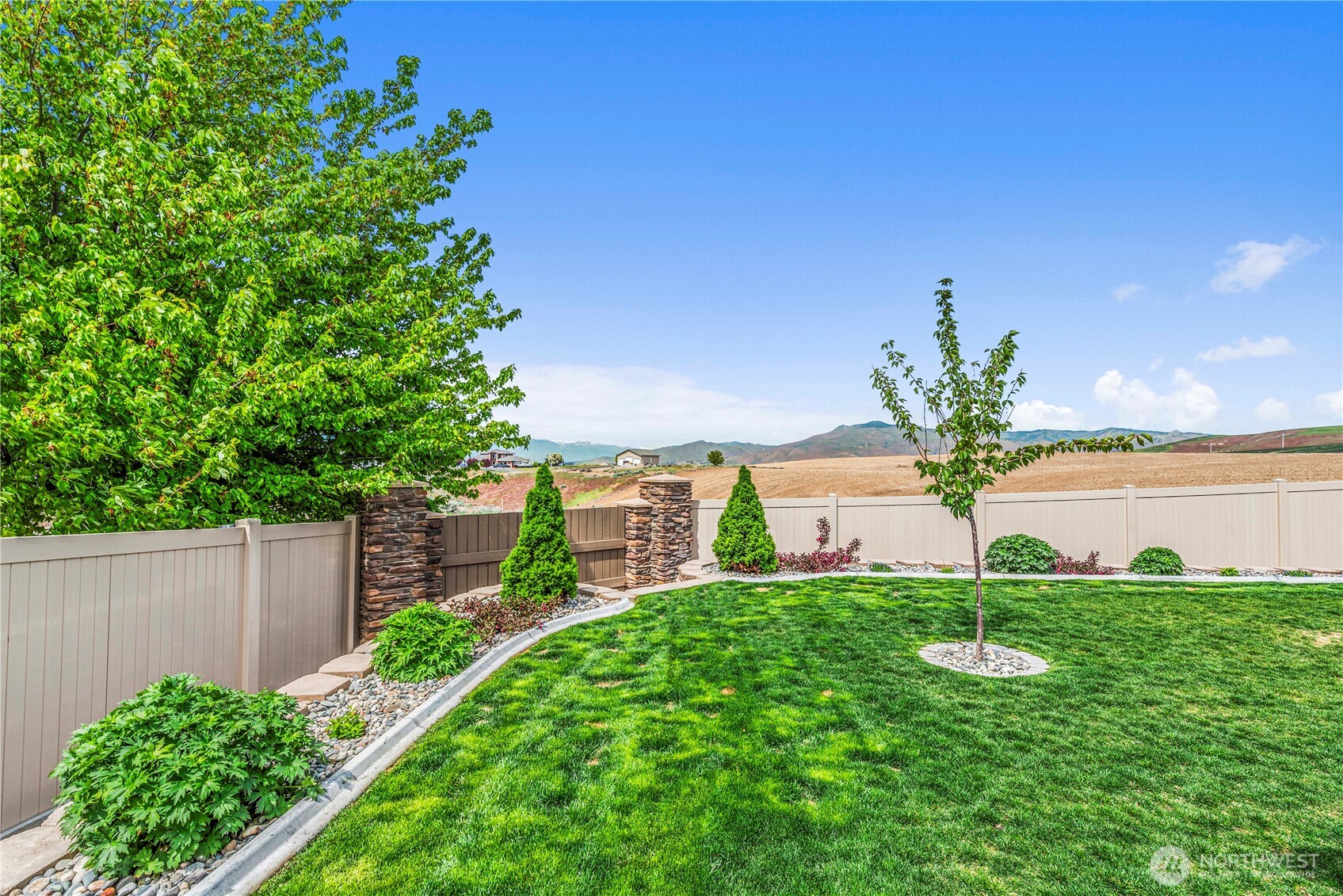 1308 Tractor Loop East Wenatchee, WA 98802 - Photo 29 of 35 a view of a garden with a building in the background