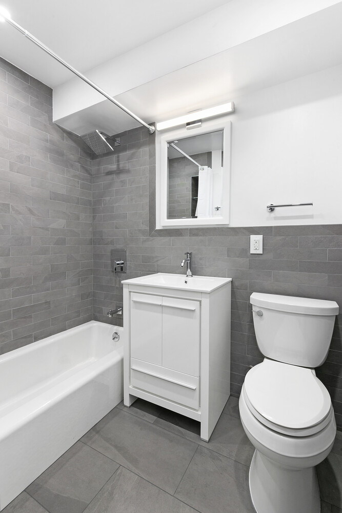 211 East 53rd Street, Unit 3M Manhattan, NY 10022 - Photo 5 of 11 a bathroom with a sink a toilet and bathtub
