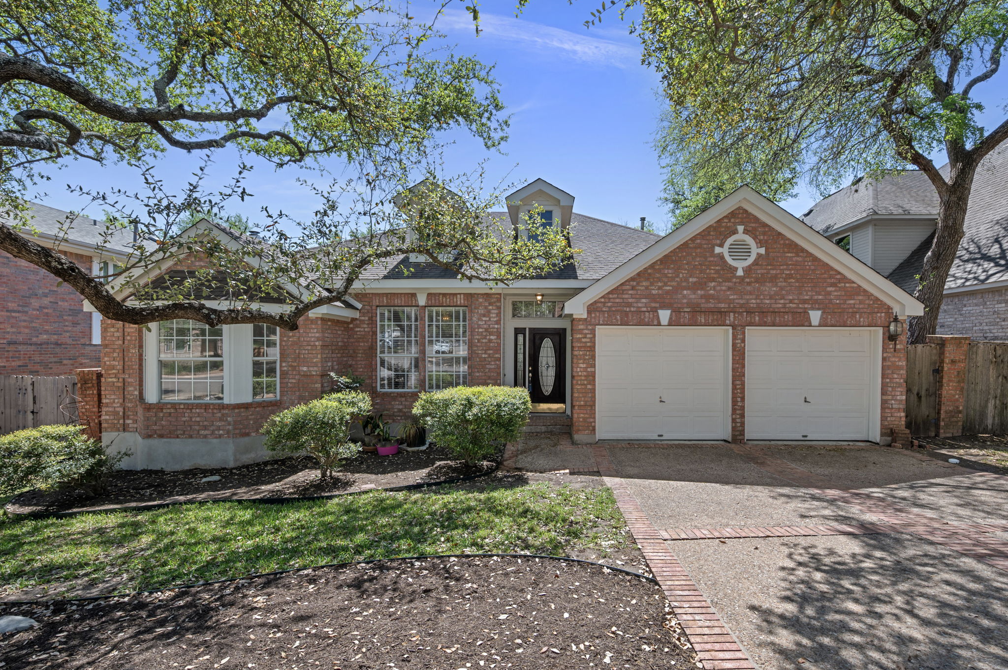 10831 Redmond Road Austin, TX 78739 - Photo 1 of 1 View of front of house with an attached garage, driveway, and brick siding