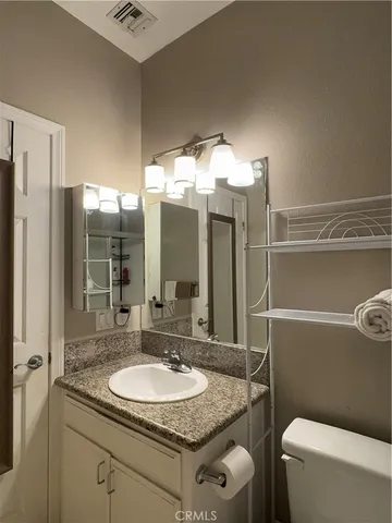 a bathroom with a granite countertop sink a mirror and a bathtub